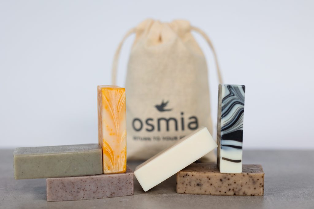 Different bars of soap in front of an Osmia pouch